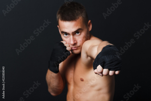 Sportsman muay thai man boxer stance at black background. © primipil