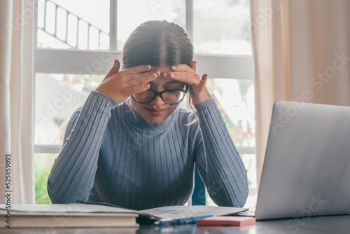 Tired bored teenage girl school student feeling headache or fatigue doing homework at home. Exhausted depressed sick teenager studying alone worried about difficult education problems concept.. photo