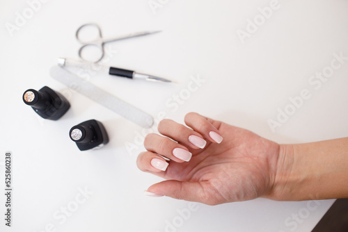 Manicure or pedicure supplies tools and hand on table.
