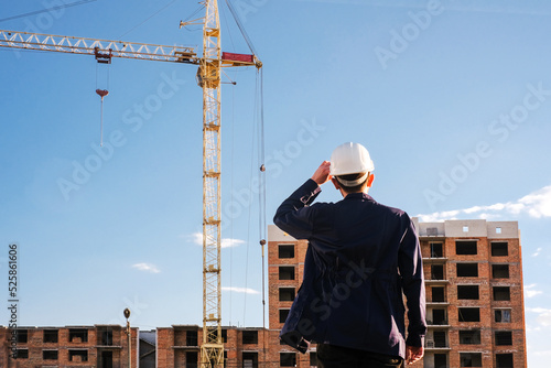engineer in uniform and safety helmet at construction site checks work