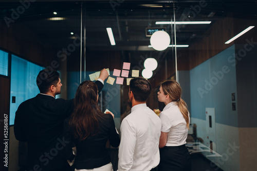 Business office team people molded on glass sticky note stickers rear back view.