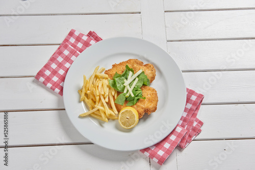 Photography Schnitzel on the place with fried potato in the plate and sauce background