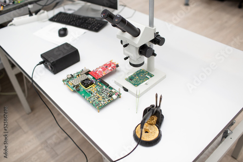 Microscope and electronic board in Scientific research tech Laboratory on table.