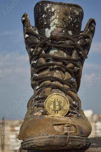Bitcoin and a shoe. A digital finance system and an old work boot.