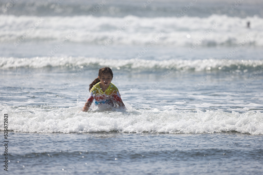 A young girl wearing a tie dye t-shirt playing in the water near the beach at Westport, Washington. A young girl wearing a tie dye t-shirt playing in the water near the beach at Westport, Washington.