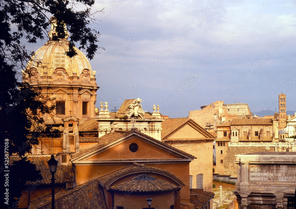 Fototapeta premium View of part of the Forum area in Rome, with the dome of the church of St. Joseph of the Carpenters, and the bell tower of the church of St Francesca in the distance