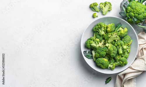 Fresh broccoli in a plate on a gray background with space to copy. Healthy, healthy food. Top view, horizontal