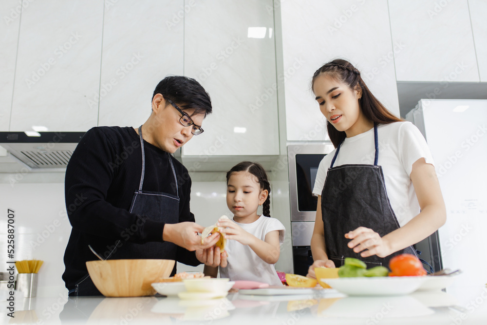Asian family cooking at home. Happy family cooks together in the kitchen home recreation and weekend meal prep. Asian family cooking at home. Happy family cooks together in the kitchen home recreation and weekend meal prep.