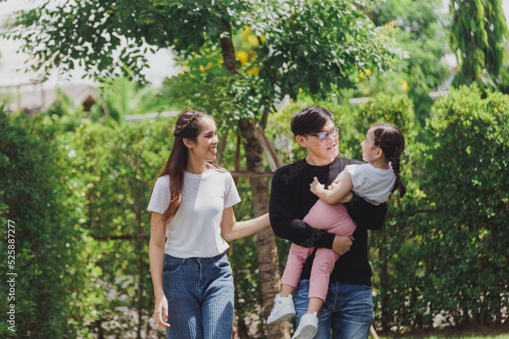 Asian Family with a child playing on a lawn, Family sitting on the grass with her happy and adorable little daughter, enjoyment relaxing recreational concept. Asian Family with a child playing on a lawn, Family sitting on the grass with her happy and adorable little daughter, enjoyment relaxing recreational concept.