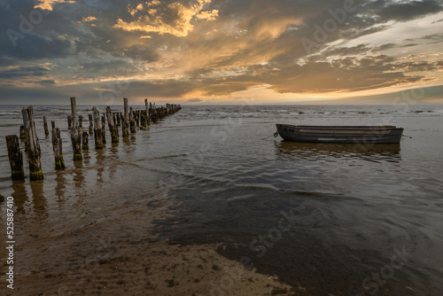 Old abandoned wooden pier or jetty remains and fishermen s boat