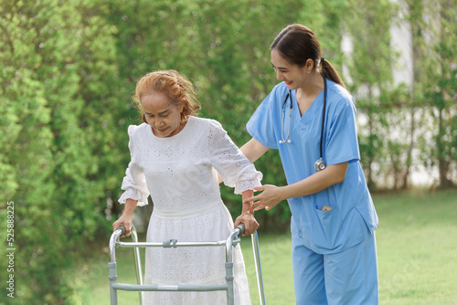 Asian young woman nurse at nursing home take care, patient and woman nurse walk in the park, man caregiver helping patient, Happiness Asian family concepts