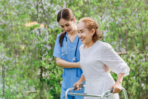 Asian young woman nurse at nursing home take care, patient and woman nurse walk in the park, man caregiver helping patient, Happiness Asian family concepts