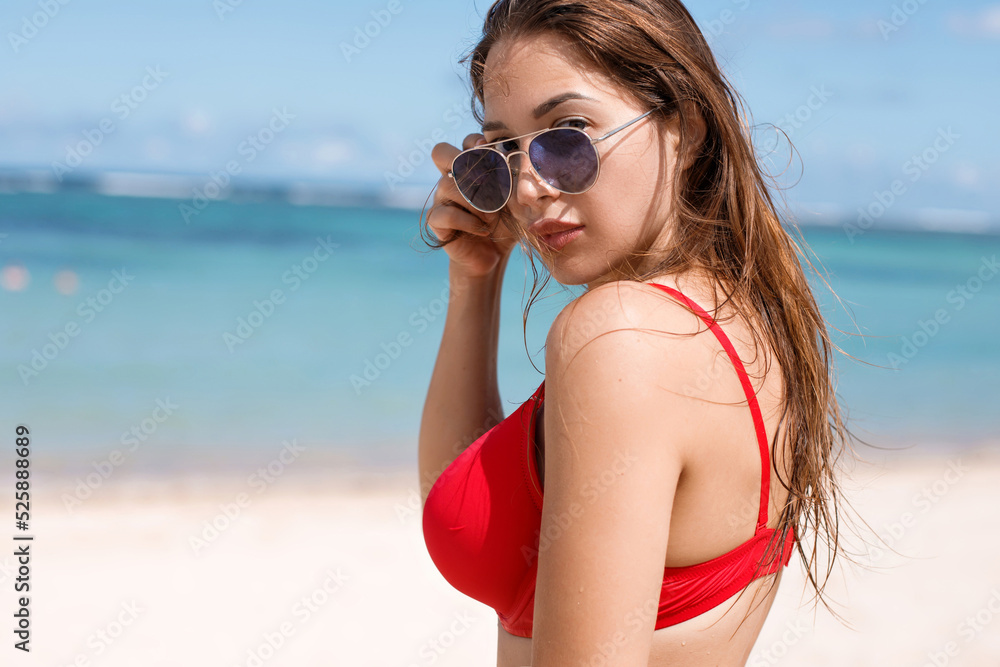 Close up of a woman in sunglasses standing at the beach Close up of a woman in sunglasses standing at the beach