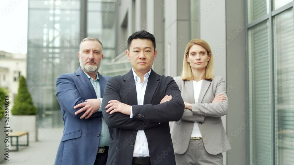 portrait of multiracial confident professional team of business people, businessmen employees in formal suits looking at camera. Group office workers outside Asian man, Caucasian woman and mature male