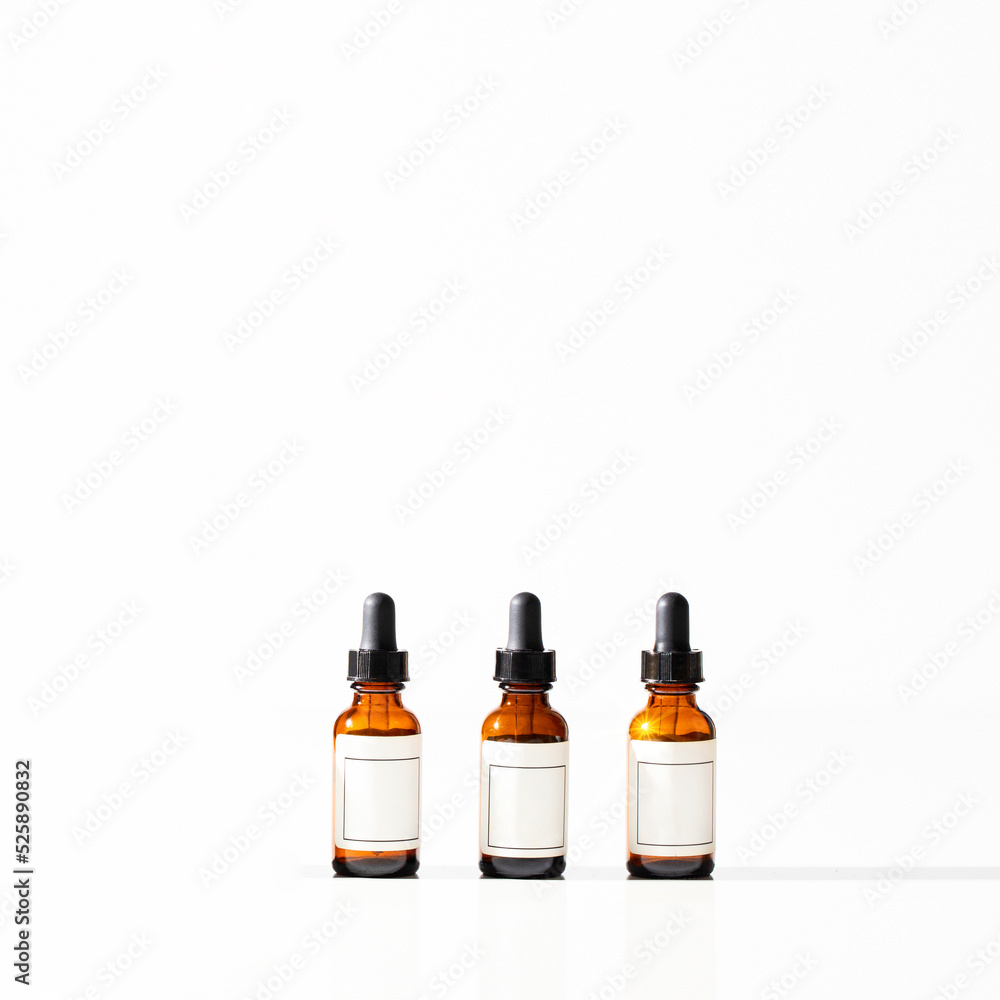 Three amber glass dropper bottles with pipette on white background. Beauty cometic product serum, oil for skin care. Copy space.. Three amber glass dropper bottles with pipette on white background. Beauty cometic product serum, oil for skin care. Copy space..