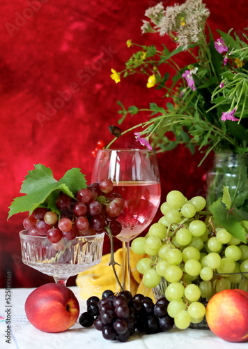 Wine and fruit on a table. Beautiful composition of juicy berries  grapes and rose wine. Harvest celebration. Textured background with copy space. 