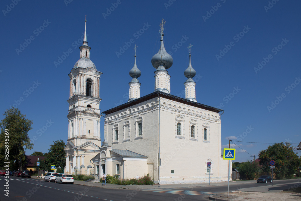 SUZDAL, Vladimir Region, Russia - August, 18, 2022: old white-stone Smolensk church with a bell tower on a sunny summer day and blue sky