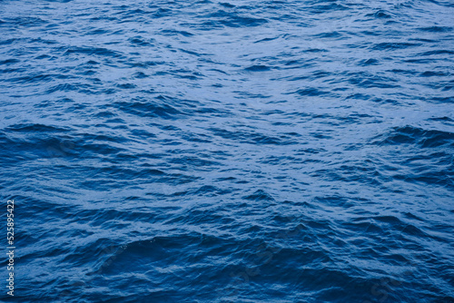 Background image of sea waves with sunlight reflected on the water surface. blue sea background in tropical sea