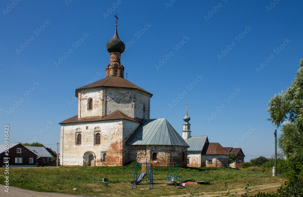 SUZDAL, Vladimir Region, Russia - August, 18, 2022: ancient white-stone Holy Cross Church on the grass on a bright sunny summer day SUZDAL, Vladimir Region, Russia - August, 18, 2022: ancient white-stone Holy Cross Church on the grass on a bright sunny summer day