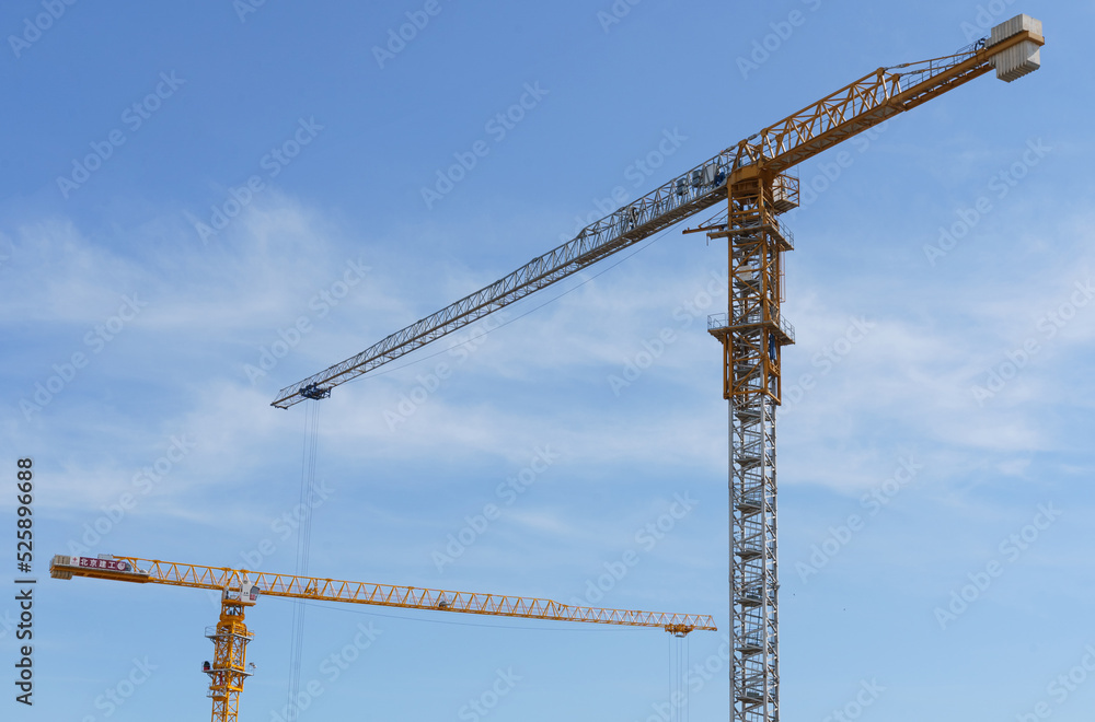 Construction cranes against the blue sky. Bottom view. Construction cranes against the blue sky. Bottom view.