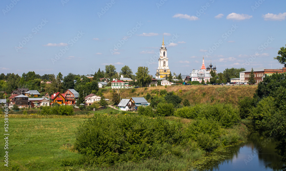 Panoramic top view of the city of Suzdal in Russia with historical architecture and a church among the lush green foliage of trees and a small river on a sunny summer day Panoramic top view of the city of Suzdal in Russia with historical architecture and a church among the lush green foliage of trees and a small river on a sunny summer day
