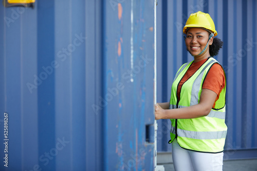young female factory worker or engineer opening the container door in warehouse storage