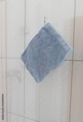 a blue washcloth is hanging in a bathroom on a glass door
 photo