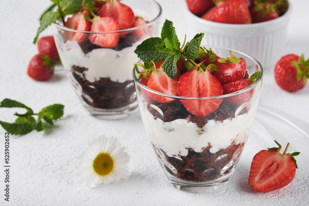 Trifles. Brownies, fresh strawberry and mascarpone cream servered in layers on glass on white background. Portion desserts. No baked brownie cheesecake with fresh berries in a glass. Trifles. Brownies, fresh strawberry and mascarpone cream servered in layers on glass on white background. Portion desserts. No baked brownie cheesecake with fresh berries in a glass.