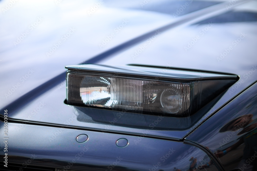 retractable headlight close-up on a blue sports car