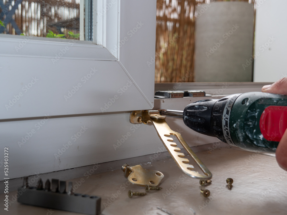 installation of a window stop, drilling holes for screws in plastic window frames Stock Photo
