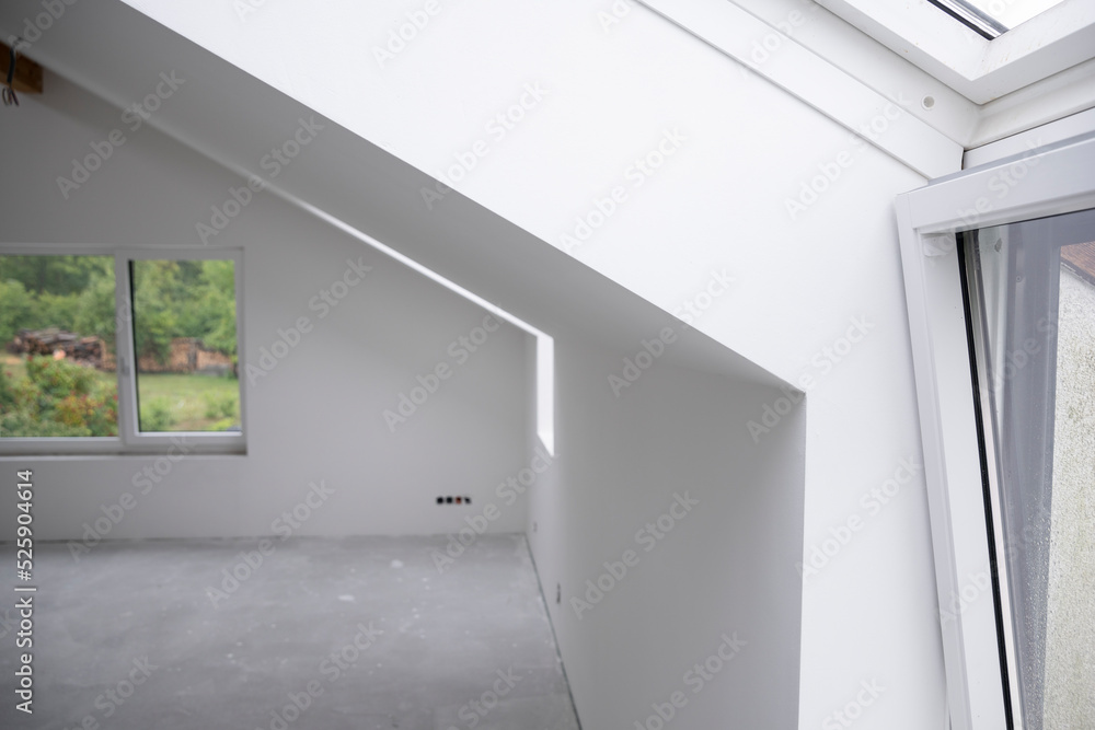 modern attic construction site freshly painted, the floor is still screed, walls are white modern attic construction site freshly painted, the floor is still screed, walls are white