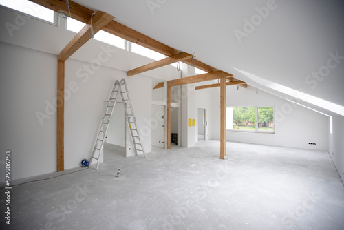 modern attic construction site freshly painted, the floor is still screed, walls are white