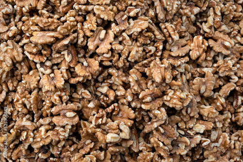 Pile of peeled raw walnut kernels, close up, background. 