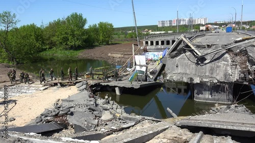 2022 - the Ukranian army on patrol crosses near the the destroyed bridge at Irpin, Ukraine. photo