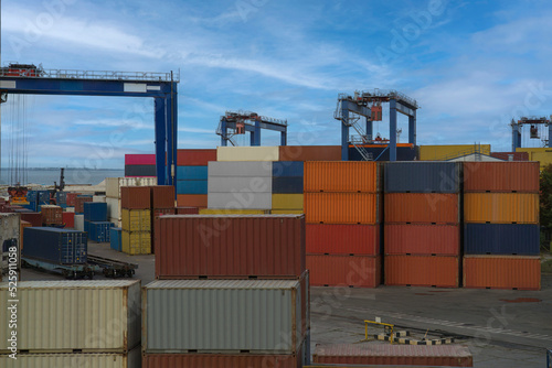 industrial port with containers. Stacks of containers in port at terminal. Berthing cranes