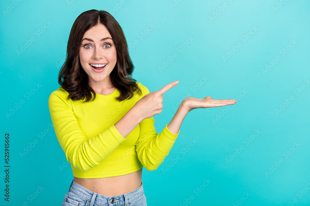 Photo of young attractive pretty cute girl hold hand demonstrating showing finger pointing empty space shock ad isolated on cyan color background Photo of young attractive pretty cute girl hold hand demonstrating showing finger pointing empty space shock ad isolated on cyan color background