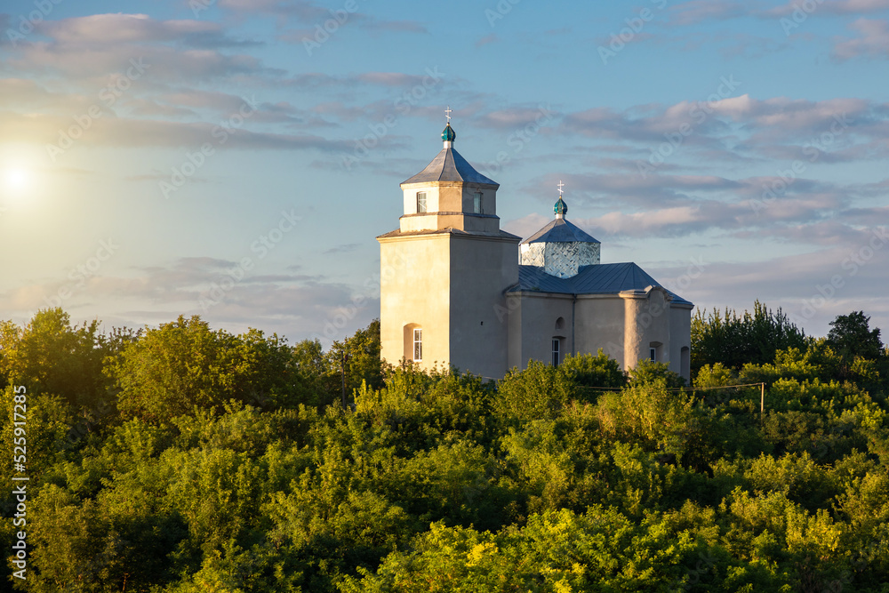 The old church above the river in the Ukrainian village on a summer evening.