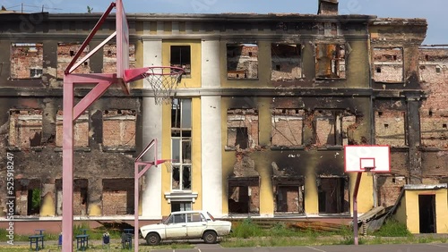 2022 - A badly damaged school building with basketball court foreground in Saltivka, Kharkiv, Ukraine. photo
