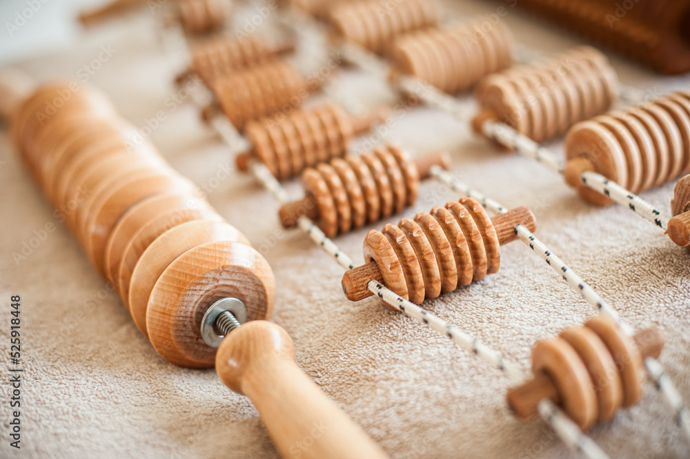 Wood massage, maderotherapy, wooden rolling pin or battledore tools for anti cellulite treatment to stimulate the lymphatic system and improve circulation concept Wood massage, maderotherapy, wooden rolling pin or battledore tools for anti cellulite treatment to stimulate the lymphatic system and improve circulation concept