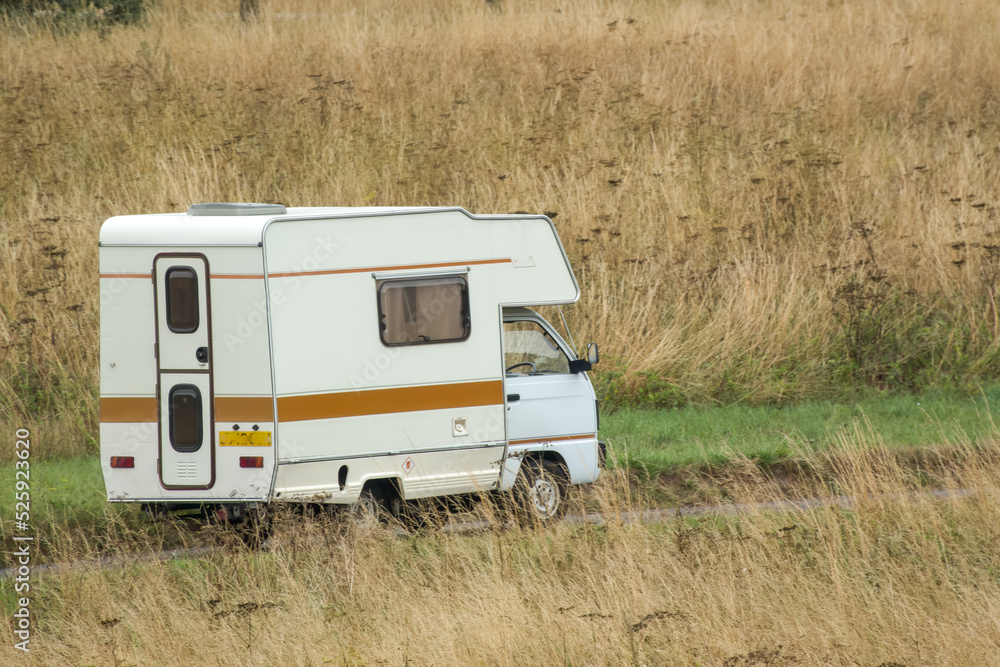 Vauxhall Bedford Rascal 1991 Nipper, 3 Berth, Overcab bed Campervan driving through parched summer countryside