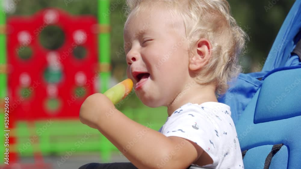 Funny kid making faces while eating popsicle on a summer day, 1.5 year old toddler face closeup. Funny kid making faces while eating popsicle on a summer day, 1.5 year old toddler face closeup.