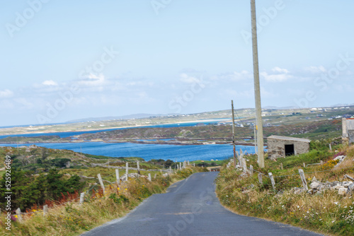 Obraz na płótnie Irish country road showing the coastline in the background w salonie