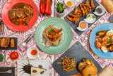 Set of plates with delicious Spanish recipes and tapas, seafood soup, hamburger, croquettes, braised tongue meat, tempura prawns and chocolate cake