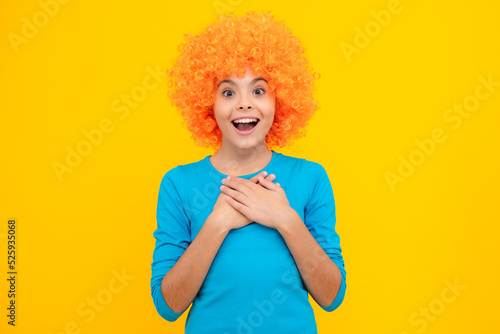 Teenage girl with yellow wig. Funny child wearing orange curly wig hair. Excited teenager, glad amazed and overjoyed emotions.