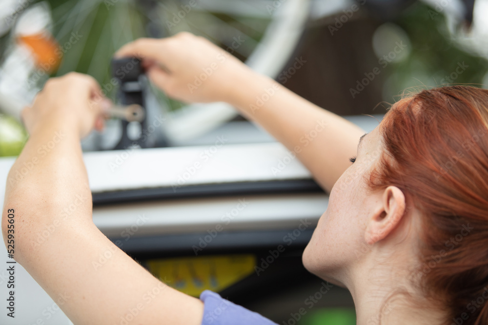 Fototapeta premium backview of woman with a bike on the roof