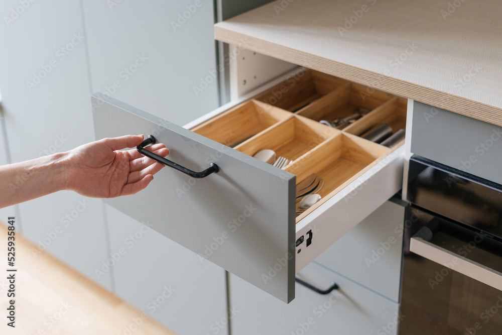 hand open cutlery drawer at contemporary kitchen - obrazy, fototapety, plakaty 