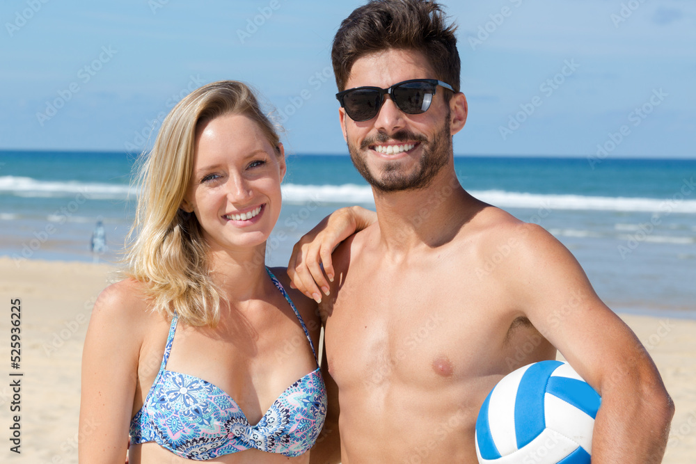 happy active man and woman playing volleyball on beach together happy active man and woman playing volleyball on beach together