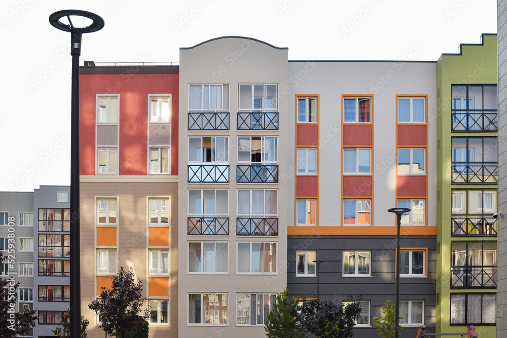 The stylish facade of a residential building with beautiful windows is a new multi-apartment residential quarter of European houses. The stylish facade of a residential building with beautiful windows is a new multi-apartment residential quarter of European houses.