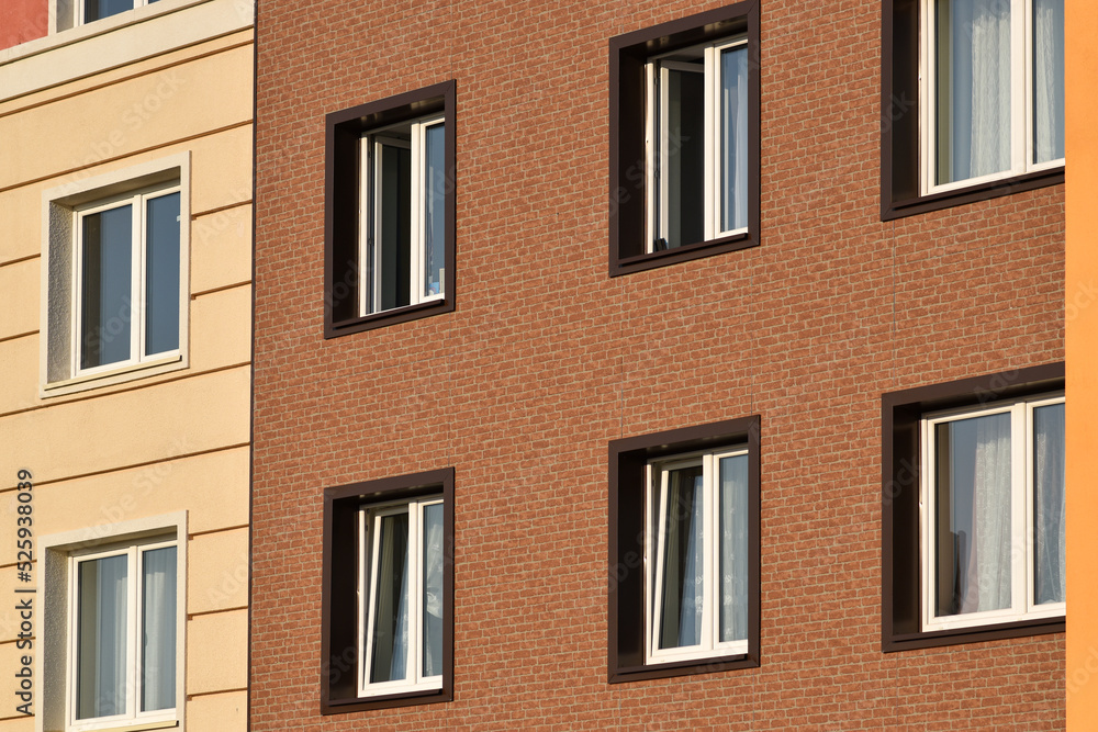 A close-up of the windows of a residential building with beautiful windows is a new multi-apartment residential quarter of European houses.
