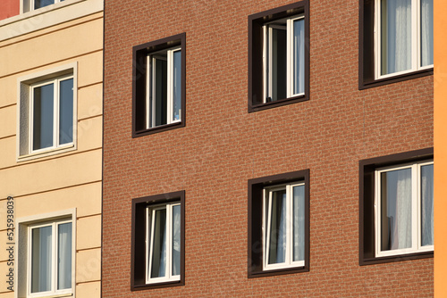 A close-up of the windows of a residential building with beautiful windows is a new multi-apartment residential quarter of European houses.